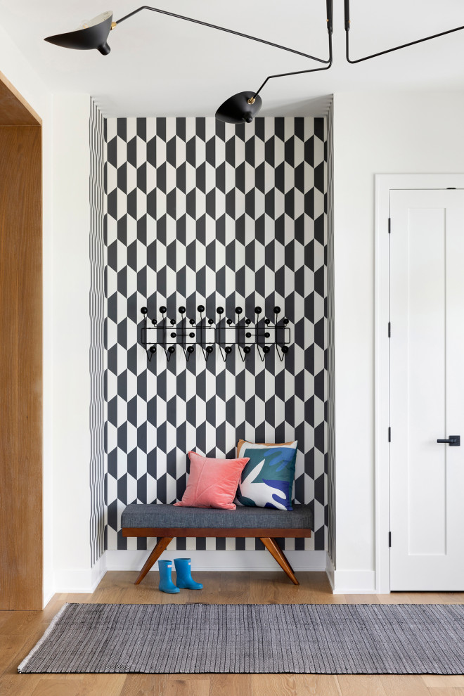 Inspiration for a large contemporary light wood floor, brown floor and wallpaper foyer remodel in Minneapolis with white walls