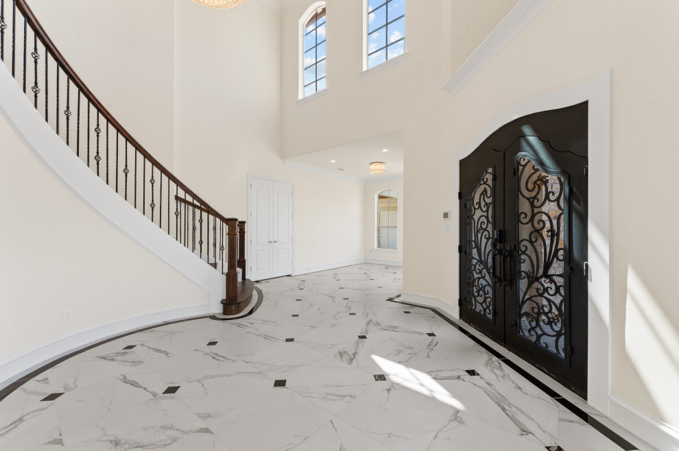 ダラスにある高級な広い地中海スタイルのおしゃれな玄関ロビー (白い壁、磁器タイルの床、黒いドア、白い床、三角天井) の写真