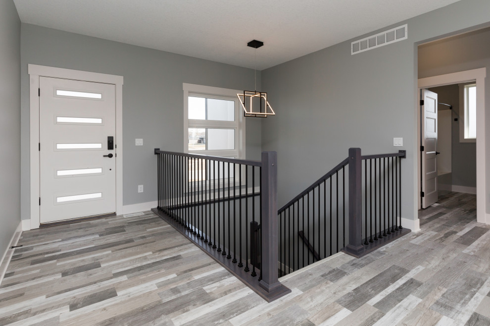 This is an example of a medium sized modern foyer in Other with grey walls, vinyl flooring, a single front door, a white front door and grey floors.