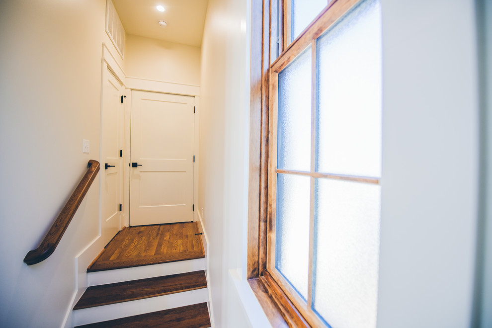 Foto de entrada de estilo americano con paredes blancas y suelo de madera en tonos medios