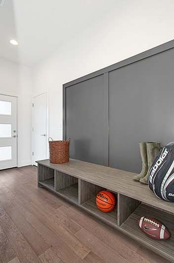 Photo of a medium sized contemporary boot room in Seattle with white walls, medium hardwood flooring, a single front door and a glass front door.