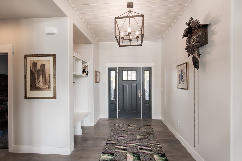 Klassische Haustür mit grauer Wandfarbe, braunem Holzboden, Einzeltür, schwarzer Haustür und beigem Boden in Boise
