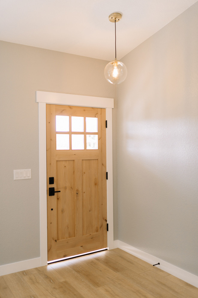 Идея дизайна: входная дверь среднего размера в стиле кантри с серыми стенами, светлым паркетным полом, одностворчатой входной дверью, входной дверью из светлого дерева и коричневым полом