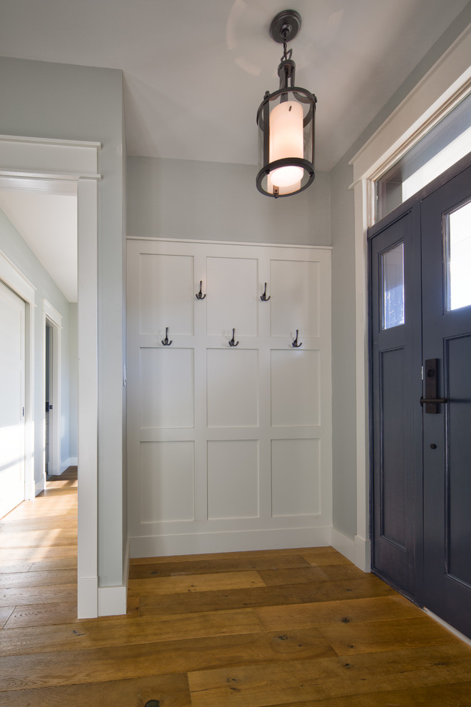 Foto di una porta d'ingresso moderna di medie dimensioni con pareti bianche, pavimento in legno massello medio, una porta singola, una porta blu e pavimento marrone