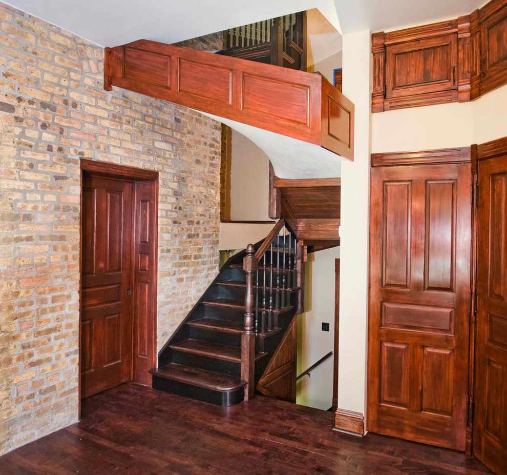 Inspiration for a timeless dark wood floor and brick wall foyer remodel in Chicago with beige walls