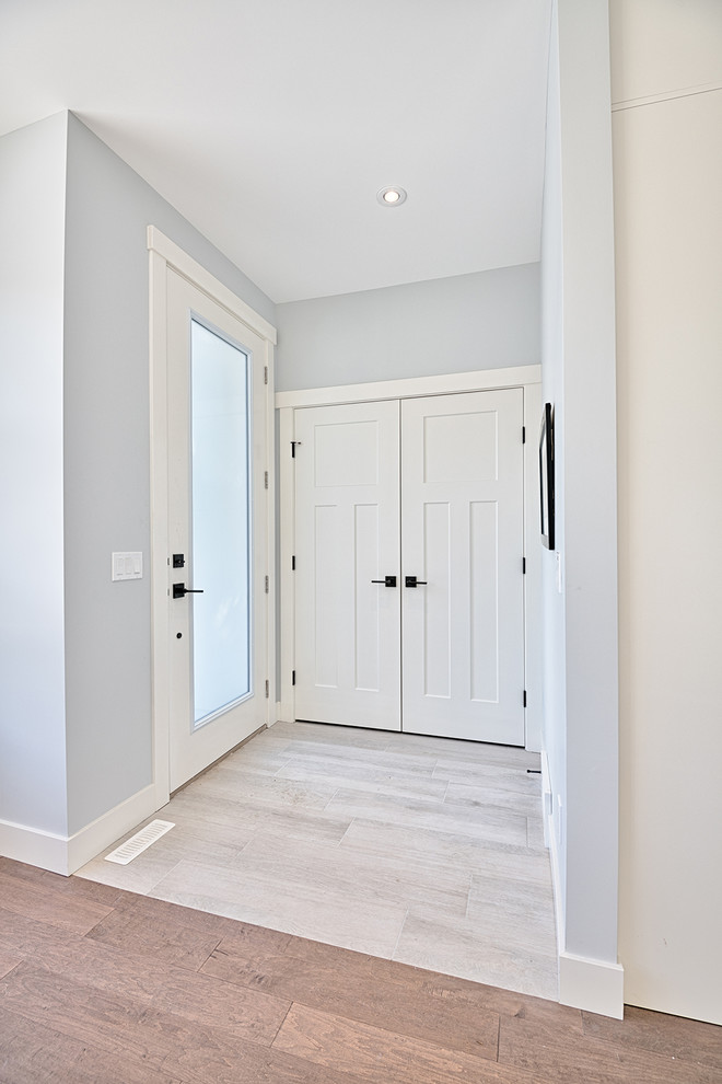 Aménagement d'un hall d'entrée classique de taille moyenne avec un mur gris, une porte simple, une porte blanche, un sol gris et un sol en carrelage de porcelaine.