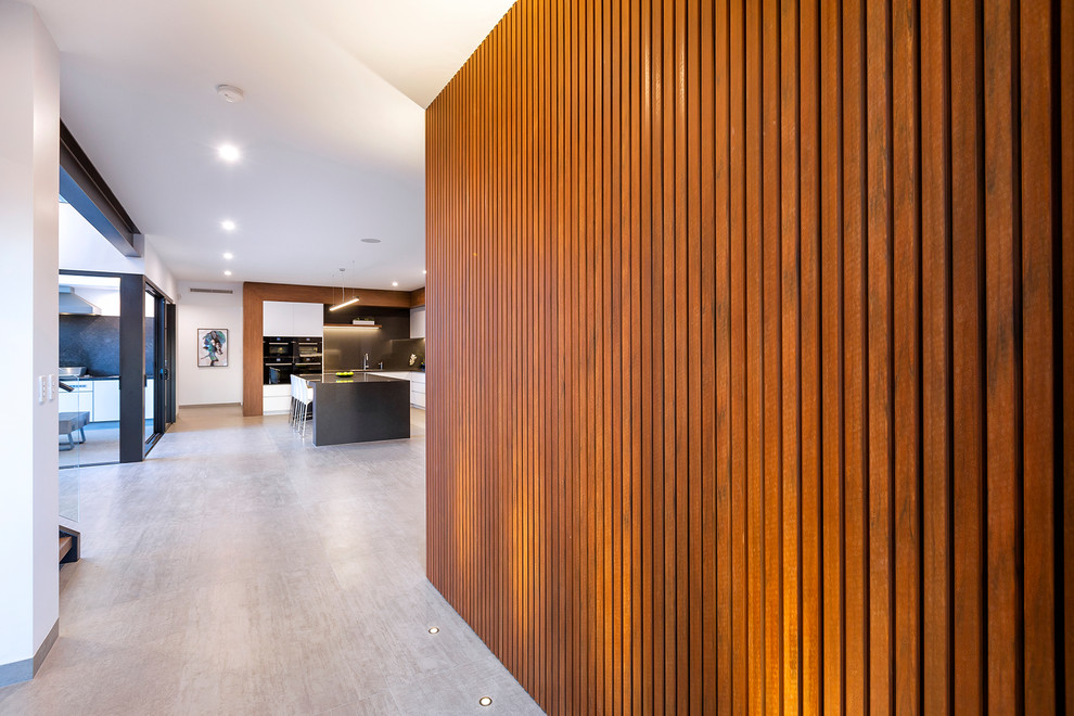 Modernes Foyer mit brauner Wandfarbe, Keramikboden, Drehtür, dunkler Holzhaustür, beigem Boden und Holzdielenwänden in Perth
