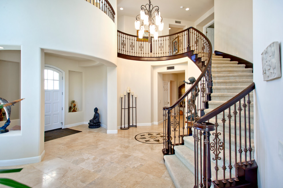 Design ideas for a large mediterranean foyer in Orange County with travertine flooring and a single front door.