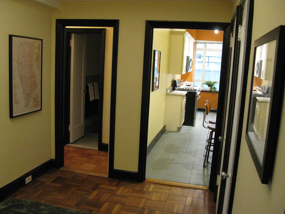 Entryway - large modern medium tone wood floor and brown floor entryway idea in New York with yellow walls and a white front door