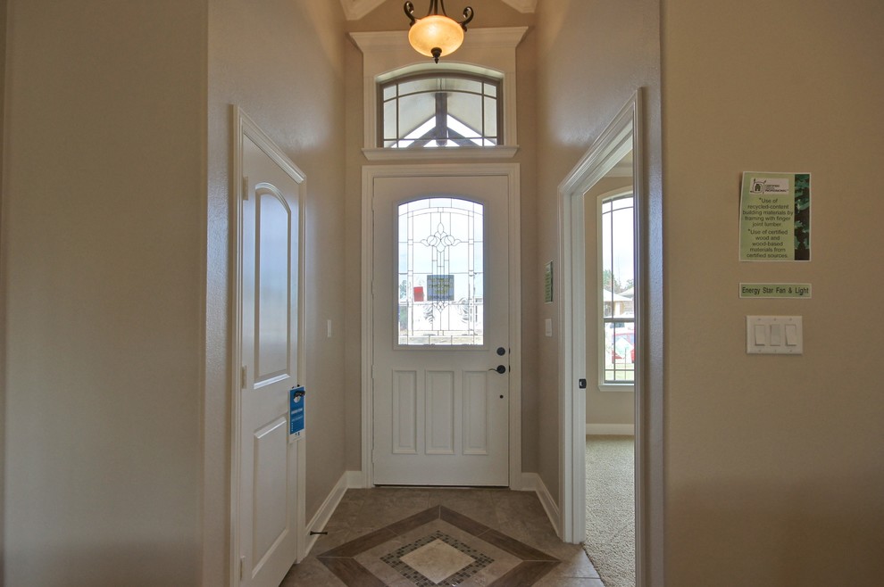 Ejemplo de distribuidor clásico de tamaño medio con paredes beige, suelo de baldosas de porcelana, puerta simple y puerta blanca