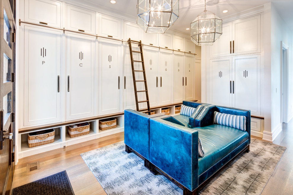This is an example of an expansive classic boot room in Salt Lake City with white walls, medium hardwood flooring, a single front door, a dark wood front door and brown floors.