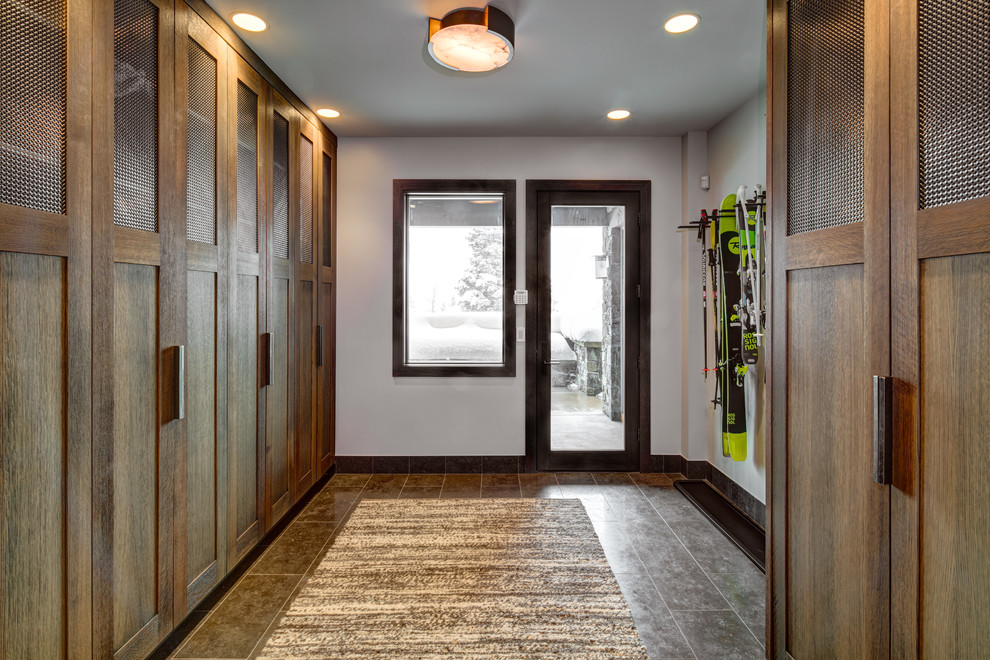 Idee per un ingresso con anticamera rustico di medie dimensioni con pareti bianche, pavimento in gres porcellanato, una porta singola, una porta in legno scuro e pavimento marrone