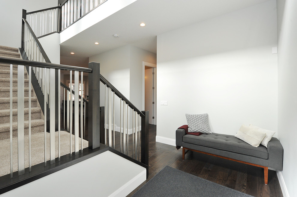 Réalisation d'un petit hall d'entrée minimaliste avec un mur gris, parquet foncé, une porte simple, une porte en bois foncé et un sol marron.