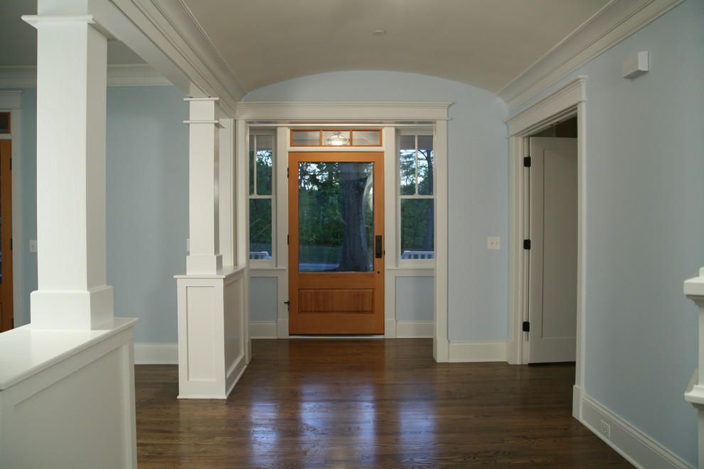 Réalisation d'un hall d'entrée tradition de taille moyenne avec un mur bleu, parquet foncé, une porte simple et une porte en verre.