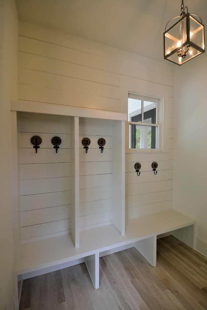 Design ideas for a small contemporary boot room in Atlanta with white walls, light hardwood flooring and beige floors.