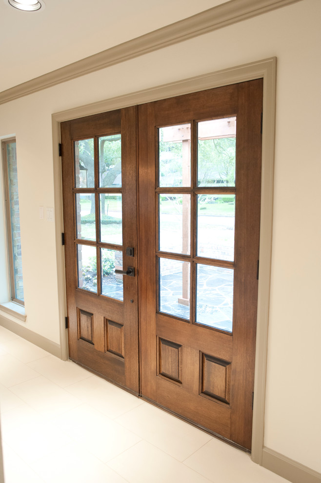 Exemple d'une porte d'entrée chic de taille moyenne avec un mur blanc, un sol en carrelage de porcelaine, une porte double et une porte en bois brun.