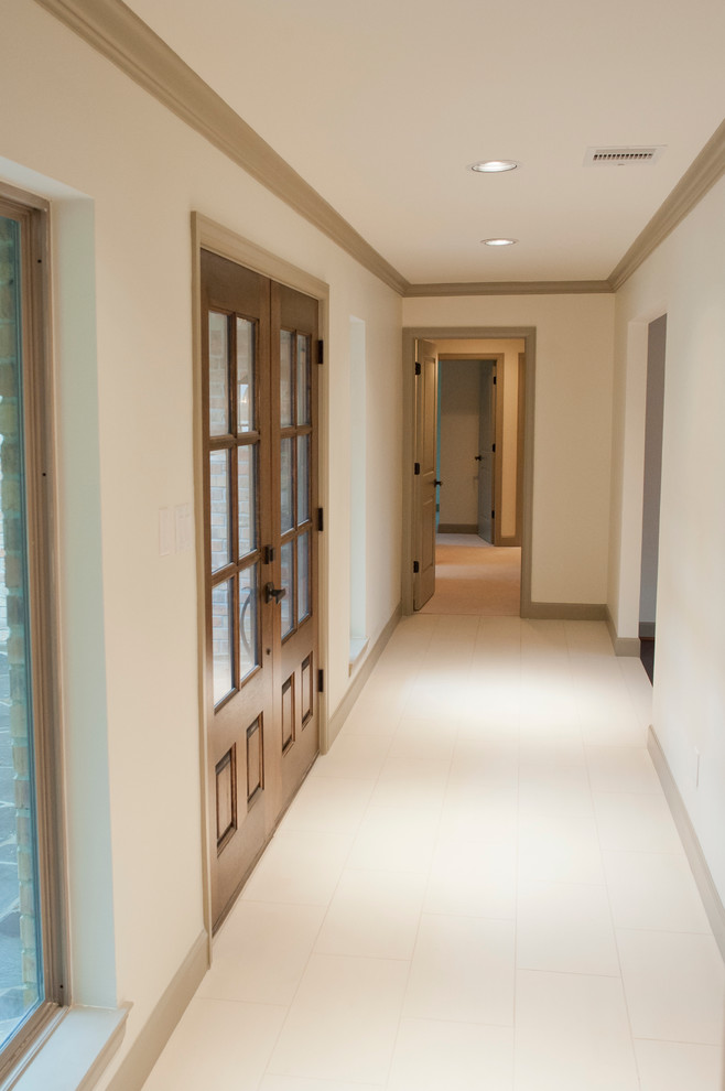 Immagine di una porta d'ingresso classica di medie dimensioni con pareti bianche, pavimento in gres porcellanato, una porta a due ante e una porta in legno bruno