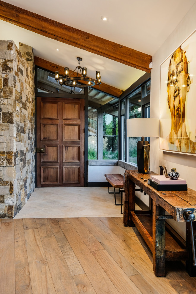 Inspiration for a rustic entrance in San Francisco with white walls, a single front door, a medium wood front door, beige floors, exposed beams and a vaulted ceiling.