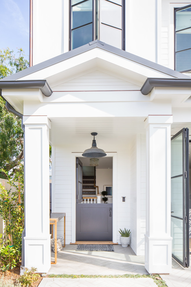 Maritime Haustür mit weißer Wandfarbe, Klöntür, grauer Haustür und grauem Boden in Los Angeles