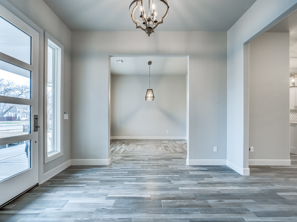 Photo of an expansive contemporary foyer in Oklahoma City with grey walls, light hardwood flooring, a single front door and a blue front door.