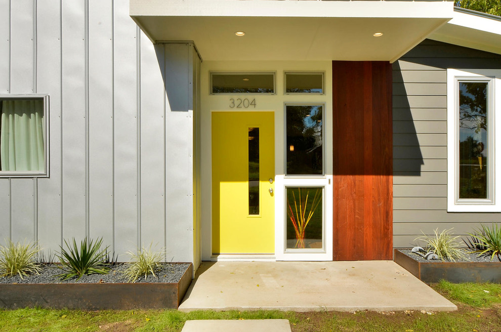 オースティンにあるコンテンポラリースタイルのおしゃれな玄関 (黄色いドア) の写真