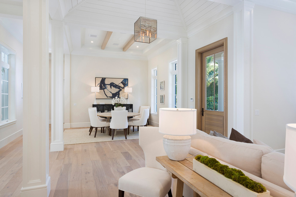 Large world-inspired front door in Miami with white walls, light hardwood flooring, a single front door, a light wood front door and beige floors.