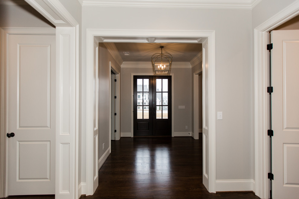 Пример оригинального дизайна: фойе среднего размера в современном стиле с бежевыми стенами, темным паркетным полом, двустворчатой входной дверью, черной входной дверью и коричневым полом