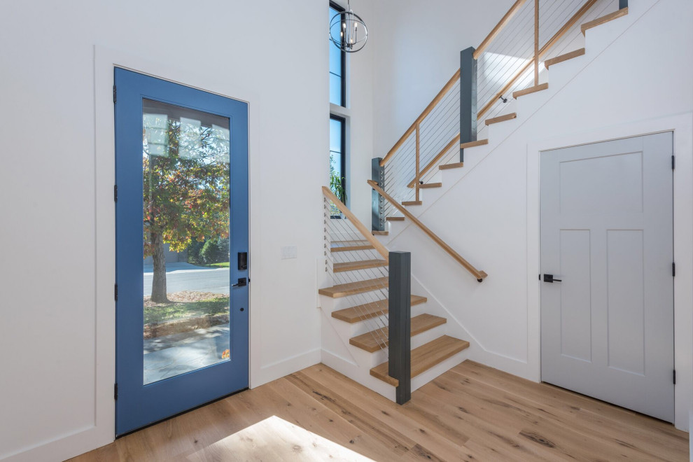 Идея дизайна: фойе среднего размера в стиле неоклассика (современная классика) с белыми стенами, светлым паркетным полом, одностворчатой входной дверью, синей входной дверью и коричневым полом