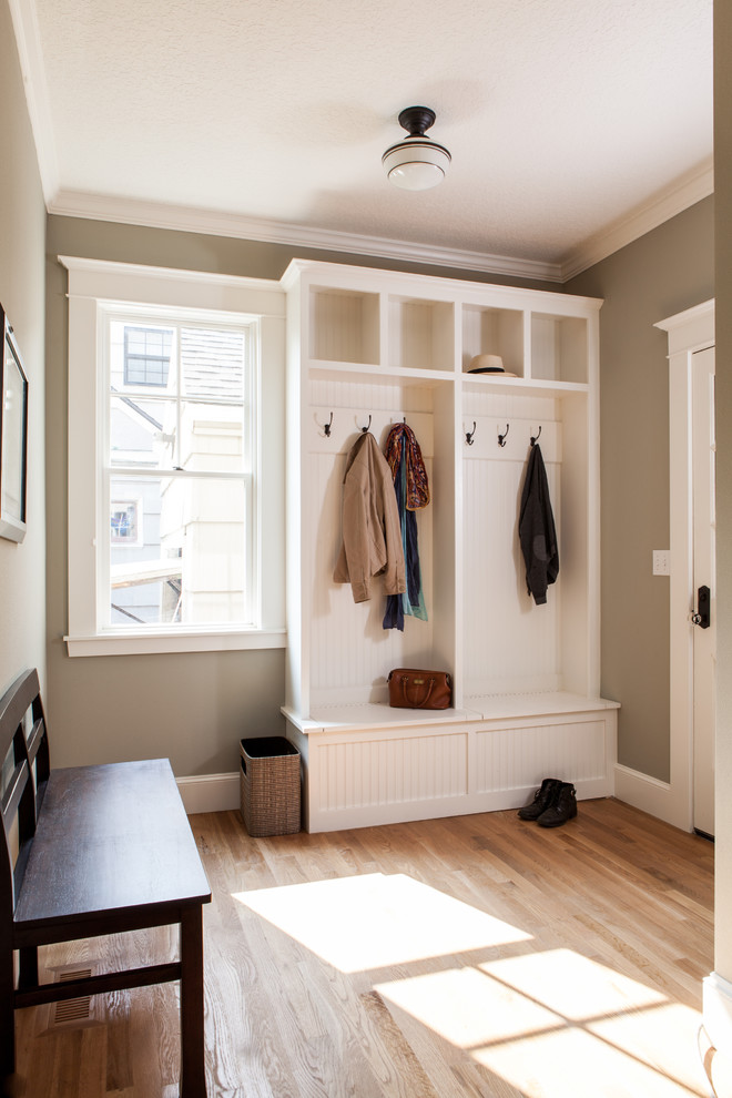 Photo of a small traditional boot room in Orange County with brown walls, light hardwood flooring, a single front door, a white front door, beige floors and feature lighting.