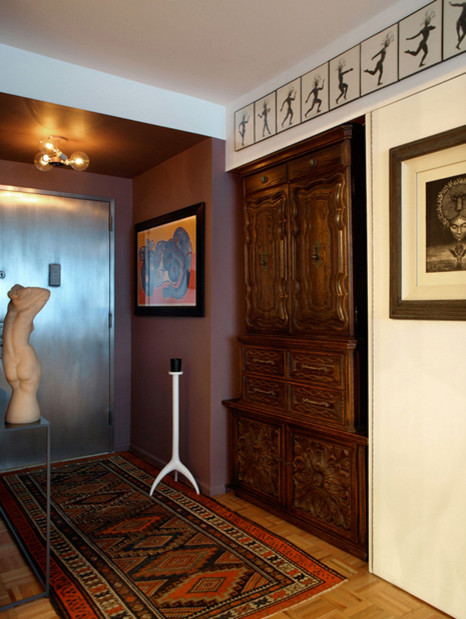 Esempio di un piccolo corridoio minimalista con pareti multicolore, pavimento in legno massello medio, una porta singola e una porta in metallo