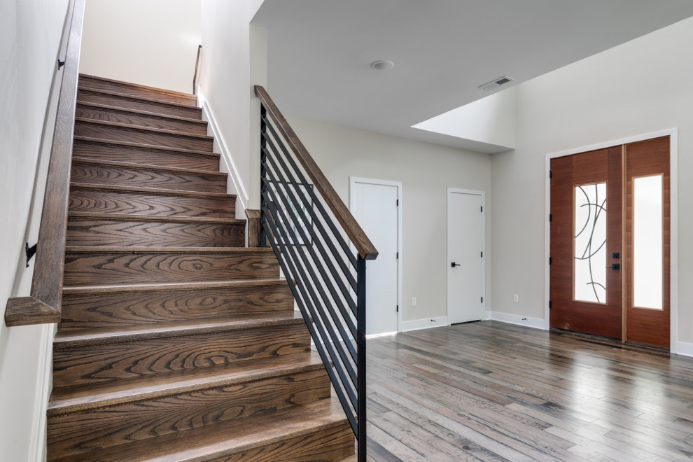 Esempio di un ingresso minimalista di medie dimensioni con pareti beige, pavimento in legno massello medio, una porta singola, una porta in legno scuro e pavimento marrone