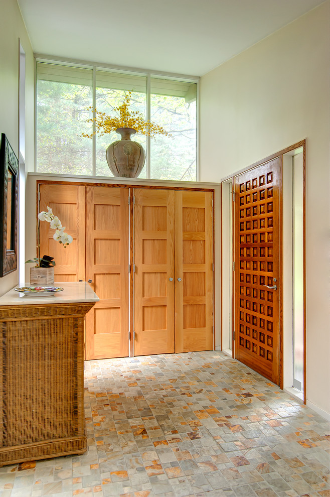 На фото: входная дверь среднего размера в современном стиле с бежевыми стенами, полом из керамической плитки, двустворчатой входной дверью, входной дверью из светлого дерева и разноцветным полом с