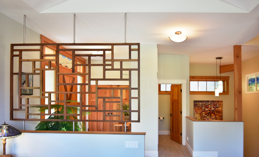 Aménagement d'un hall d'entrée craftsman de taille moyenne avec un mur vert, parquet clair, une porte pivot et une porte en bois brun.