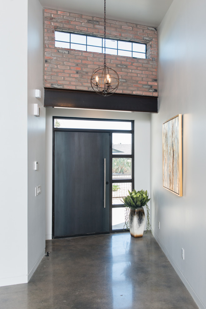 Entryway - mid-sized industrial concrete floor and gray floor entryway idea in Phoenix with white walls and a metal front door