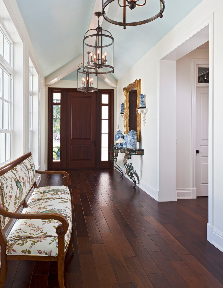 Diseño de hall clásico con paredes blancas, suelo de madera oscura, puerta simple y puerta de madera oscura