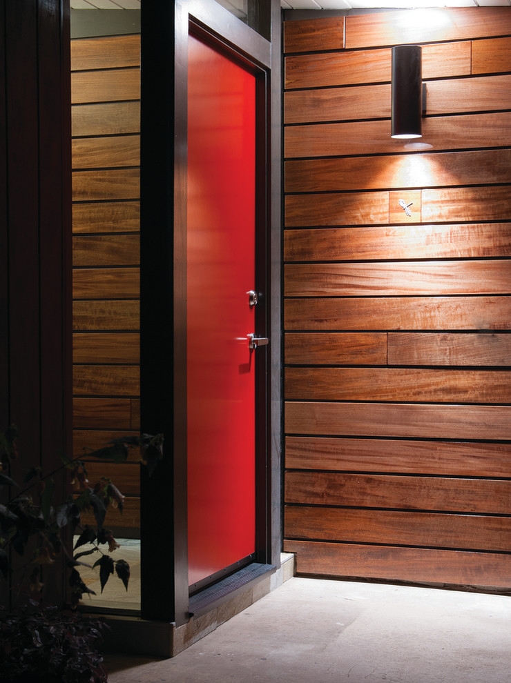 Inredning av en modern entré, med en enkeldörr och en röd dörr