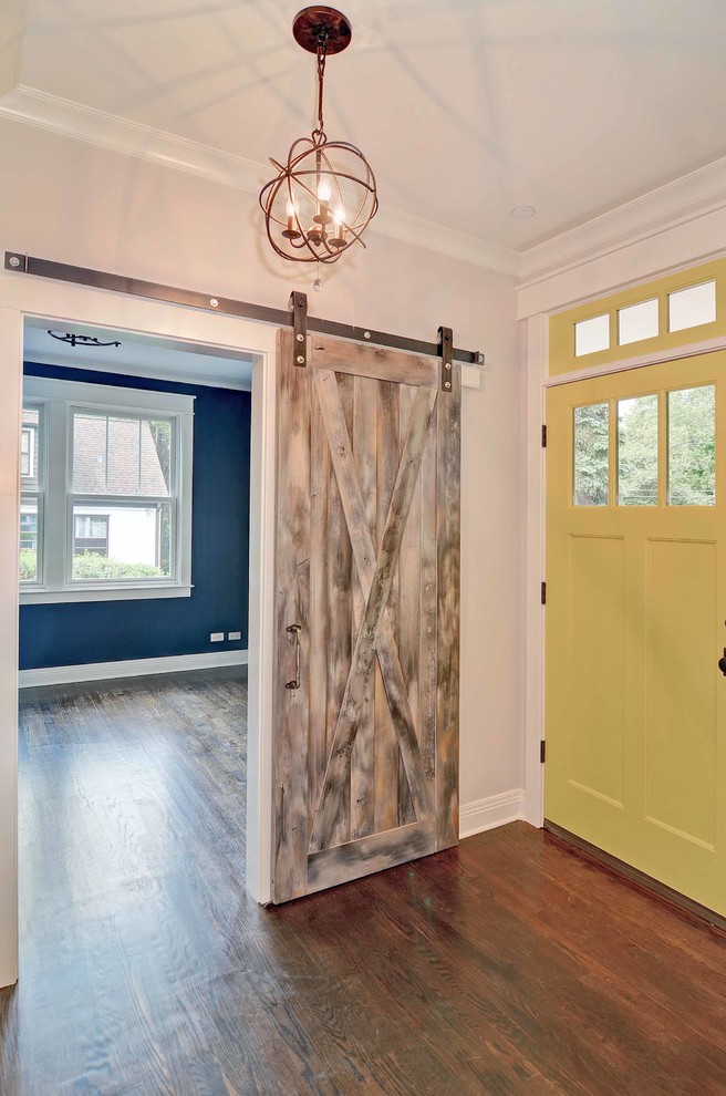 Aménagement d'une porte d'entrée classique de taille moyenne avec un mur blanc, parquet foncé, une porte simple et une porte jaune.