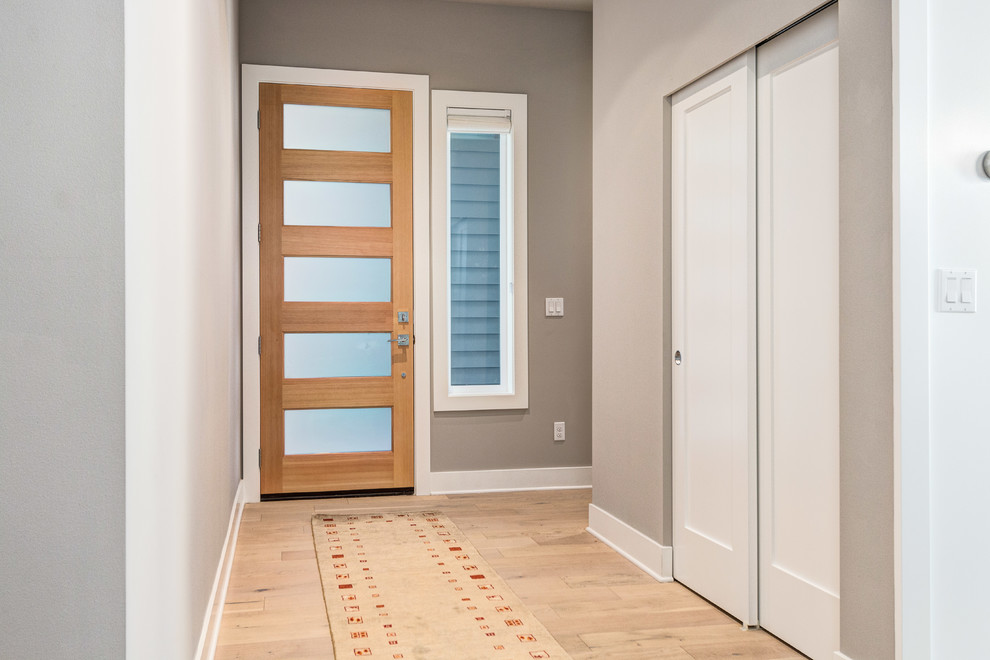 Источник вдохновения для домашнего уюта: маленькая входная дверь в стиле неоклассика (современная классика) с бежевыми стенами, светлым паркетным полом, одностворчатой входной дверью, серой входной дверью и коричневым полом для на участке и в саду