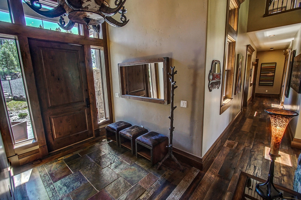 ボイシにある中くらいなラスティックスタイルのおしゃれな玄関ロビー (ベージュの壁、スレートの床、木目調のドア、マルチカラーの床) の写真
