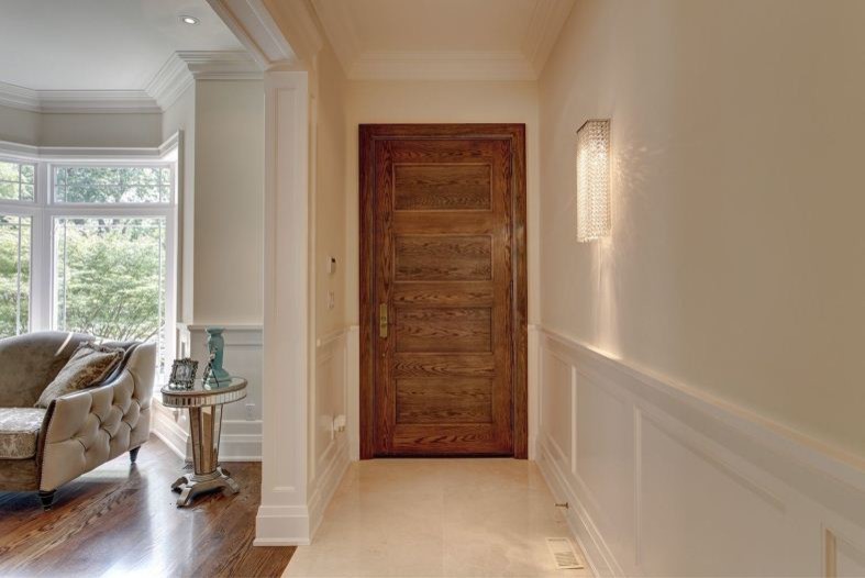 Exemple d'une porte d'entrée chic de taille moyenne avec un mur beige, un sol en carrelage de porcelaine, une porte simple et une porte en bois brun.