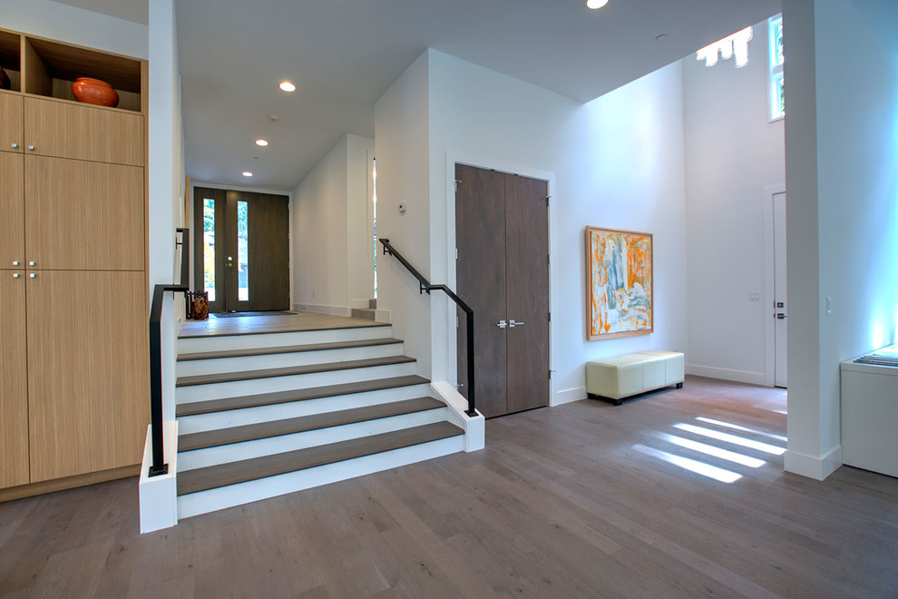 Inspiration for a large contemporary dark wood floor and brown floor entryway remodel in Seattle with white walls and a dark wood front door