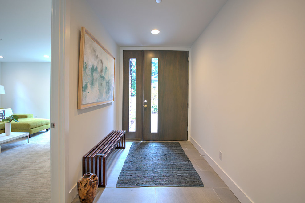 Modelo de hall contemporáneo grande con paredes blancas, suelo de madera oscura, puerta simple, puerta de madera oscura y suelo marrón