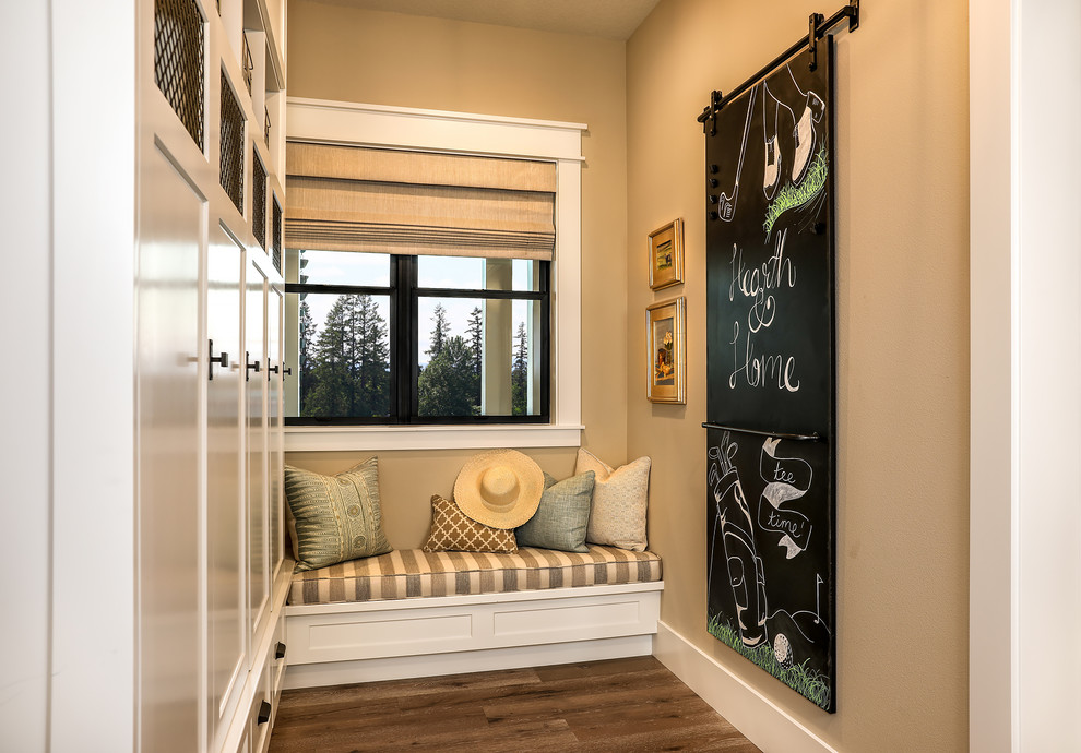 Cette photo montre une entrée nature de taille moyenne avec un mur beige, un vestiaire, un sol en bois brun, une porte en bois brun et un sol beige.