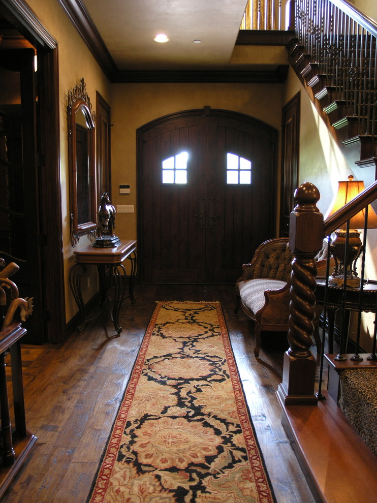 Immagine di un ingresso rustico di medie dimensioni con pareti beige, pavimento in legno massello medio, una porta a due ante, una porta in legno scuro e pavimento marrone