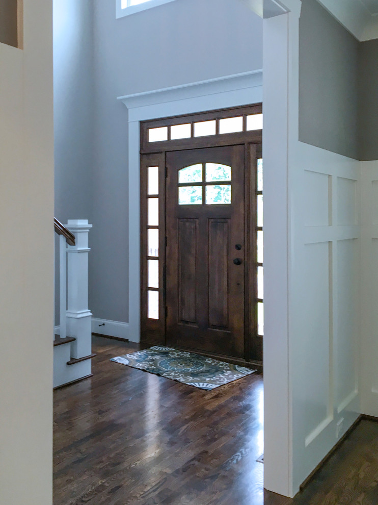 Foto di una grande porta d'ingresso classica con pareti grigie, pavimento in legno massello medio, una porta singola e una porta in legno bruno