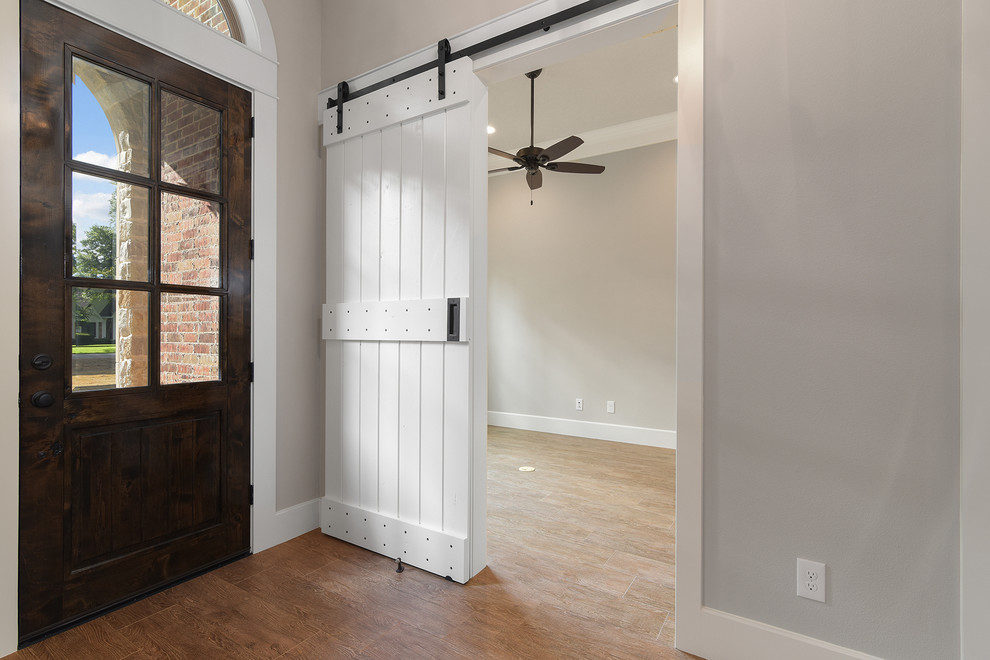 Ispirazione per una porta d'ingresso chic di medie dimensioni con pareti grigie, pavimento in gres porcellanato, una porta singola e una porta in legno scuro