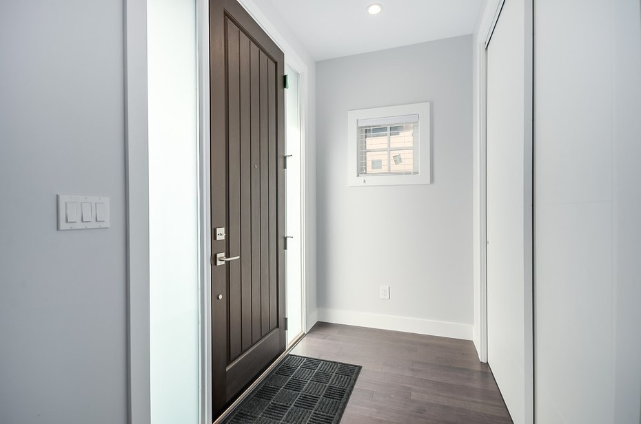 バンクーバーにある中くらいなコンテンポラリースタイルのおしゃれな玄関ドア (グレーの壁、無垢フローリング、濃色木目調のドア、茶色い床) の写真