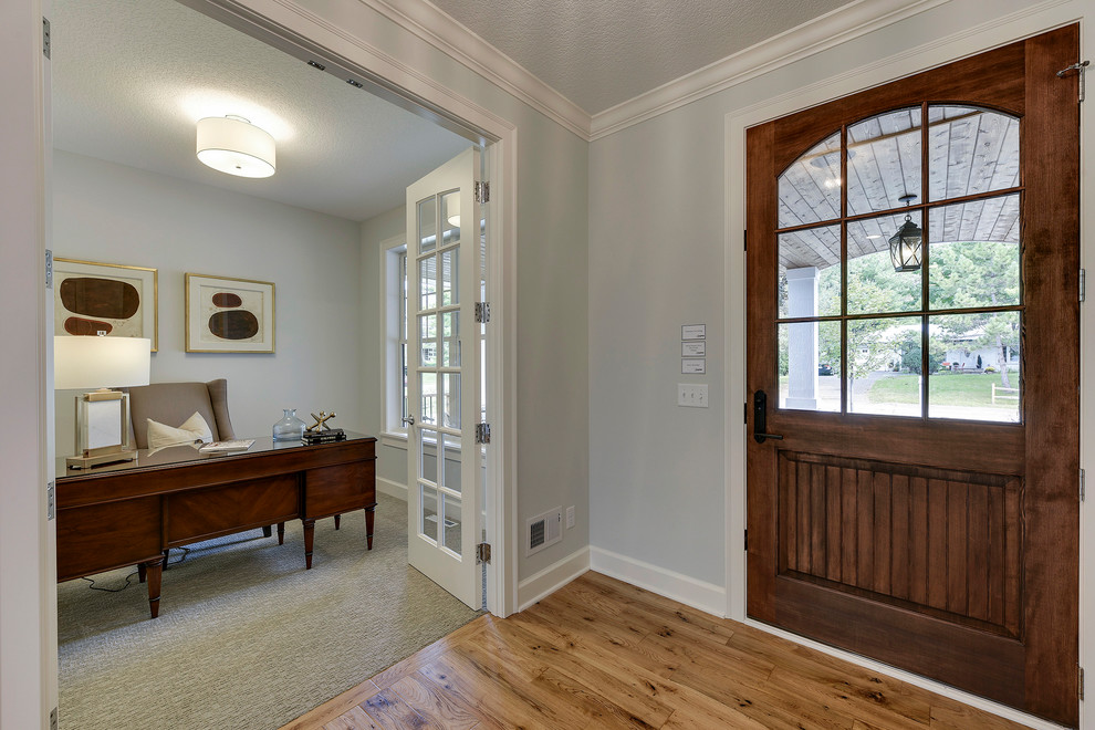 Пример оригинального дизайна: входная дверь среднего размера в классическом стиле с белыми стенами, светлым паркетным полом, одностворчатой входной дверью, входной дверью из темного дерева и коричневым полом
