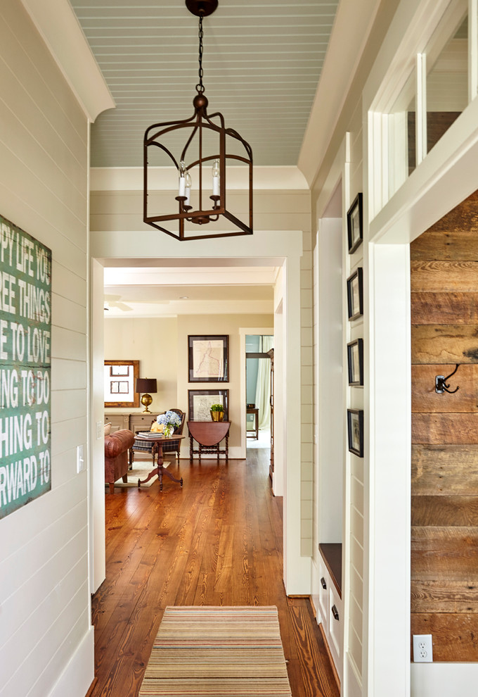 Inspiration for a mid-sized farmhouse medium tone wood floor and brown floor entryway remodel in Charlotte with beige walls and a medium wood front door