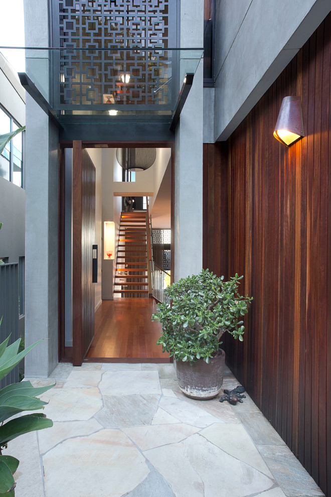 Ispirazione per un ingresso o corridoio moderno con una porta a pivot e una porta in legno bruno